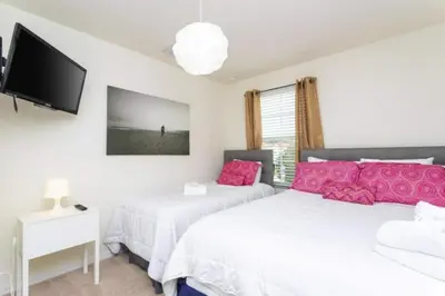 two beds with pink pillows in a bedroom at 4572 Perfect home for your family close to all parks in Kissimmee