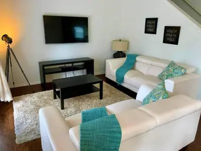 a living room with two white couches and a television at 5372 Lovely home inside Disney area in Kissimmee