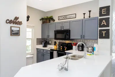 a kitchen with blue cabinets and a white counter top at 8553 Stunning house close to Animal Kingdom in Kissimmee
