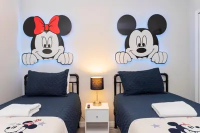 a bedroom with two beds with mickeys on the wall at 8553 Stunning house close to Animal Kingdom in Kissimmee