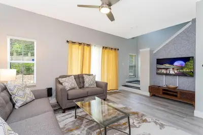 a living room with a couch and a tv at 8553 Stunning house close to Animal Kingdom in Kissimmee