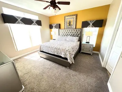 a bedroom with a bed and a ceiling fan at Mickeys Escape - Magical Lakeview 7BR - 4 Master Suites Pool & Hot Tub BBQ Home Theater and 2 Miles Disney! in Orlando