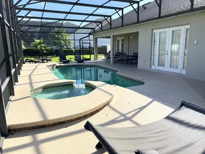 a swimming pool in the middle of a house at Mickeys Escape - Magical Lakeview 7BR - 4 Master Suites Pool & Hot Tub BBQ Home Theater and 2 Miles Disney! in Orlando