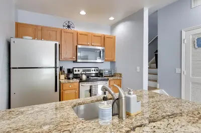 a kitchen with a refrigerator and a sink at 12 Mi to Disney Family Home with Resort Amenities! in Kissimmee
