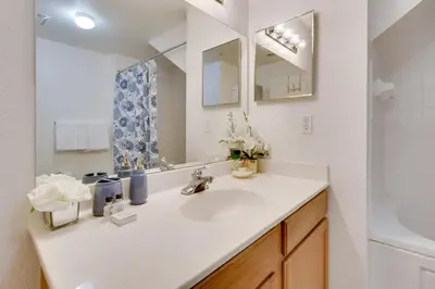 a white bathroom with a sink and a mirror at 12 Mi to Disney Family Home with Resort Amenities! in Kissimmee