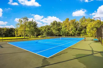 a tennis court with a blue tennis court at Villas at Seven Dwarfs Resort - Near to Disney in Kissimmee