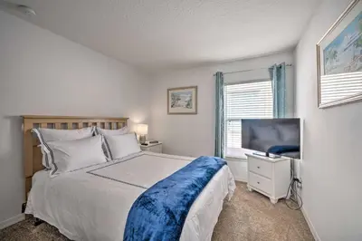 a bedroom with a large bed and a tv at Pool and Lanai Emerald Isle Resort Home! in Kissimmee