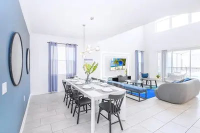 a dining room and living room with a table and chairs at Bright & Airy 5BR Resort Home with Pool in Kissimmee