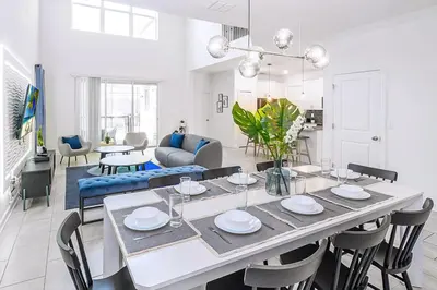 a dining room and living room with a table and chairs at Bright & Airy 5BR Resort Home with Pool in Kissimmee