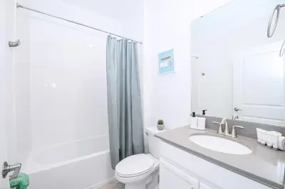 a white bathroom with a toilet and a sink at Bright & Airy 5BR Resort Home with Pool in Kissimmee