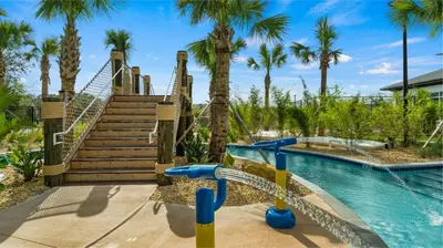 a slide in a pool at a resort with palm trees at Bright & Airy 5BR Resort Home with Pool in Kissimmee