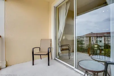 a balcony with a table and chairs and a glass door at 4814 Cayview Avenue #401 in Orlando