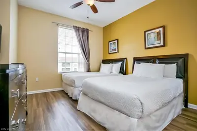 two beds in a hotel room with yellow walls at 4814 Cayview Avenue #401 in Orlando