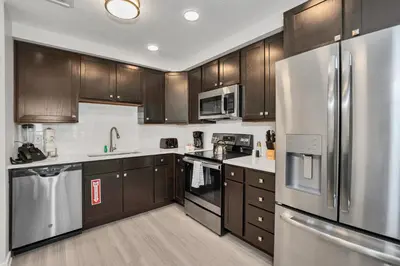 a kitchen with wooden cabinets and stainless steel appliances at Newly Renovated Condo wFREE Resort Access in Orlando