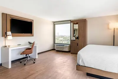 a hotel room with a bed and a desk and a window at Cambria Hotel Orlando near Universal Theme Parks in Orlando