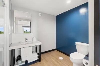 a bathroom with a white toilet and a blue wall at Cambria Hotel Orlando near Universal Theme Parks in Orlando