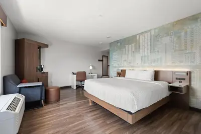 a bedroom with a large bed and a desk at Cambria Hotel Orlando near Universal Theme Parks in Orlando