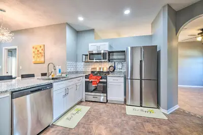a large kitchen with white appliances and blue walls at Sunny Clermont Retreat with Lanai 12 Mi to Disney! in Orlando