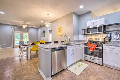 a large kitchen with white appliances and a dining room at Sunny Clermont Retreat with Lanai 12 Mi to Disney! in Orlando