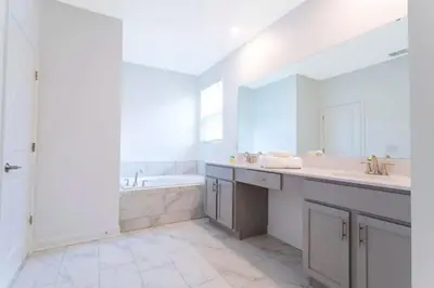a white bathroom with a tub and a sink at Stunning Family Friendly 5 Bd w/ Pool Close to Disney @ Storey Lake 4242 in Kissimmee