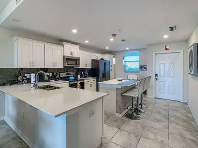 a kitchen with white cabinets and a counter top at Last minute deal! Brand New 2bed apt near Disney in Kissimmee