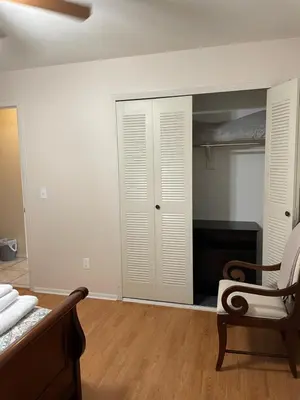 a bedroom with a bed and a chair and a closet at Sanford Lake Mary Quiet Rooms in Sanford