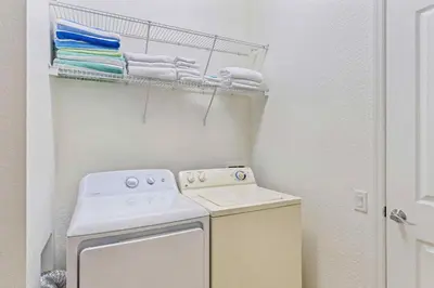 a small laundry room with a stove and towels at Vista Cay at Epic Universe - Luxury 4 bedroom penthouse in Orlando