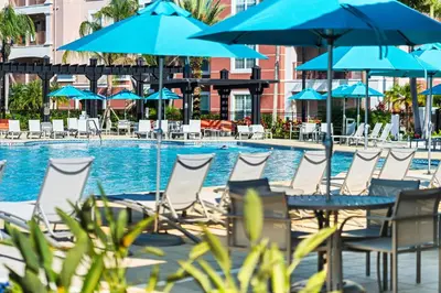 a group of chairs and umbrellas next to a swimming pool at Vista Cay at Epic Universe - Luxury 4 bedroom penthouse in Orlando