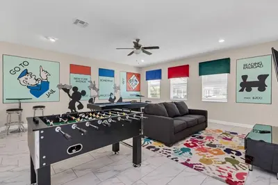 a living room with a foosball table and a couch at Monopoly Fun Storey Lake Resort 6 Bed Star Home! villa in Kissimmee