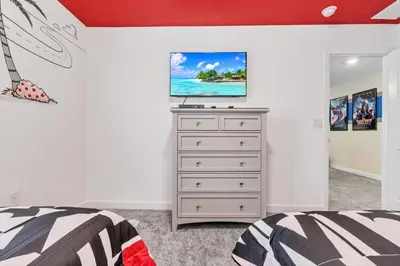 a bedroom with a bed and a dresser with a tv on it at Monopoly Fun Storey Lake Resort 6 Bed Star Home! villa in Kissimmee