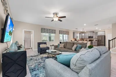 a living room with a couch and a flat screen tv at Monopoly Fun Storey Lake Resort 6 Bed Star Home! villa in Kissimmee