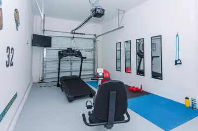 a room with a gym with a treadmill and equipment at Enchanting Decor Home with private pool in Kissimmee