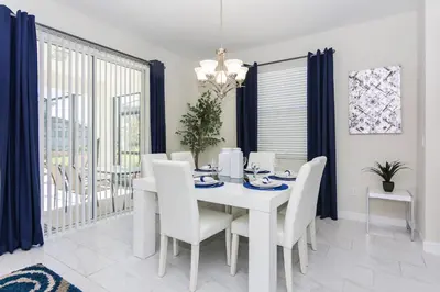 a white dining room with a white table and chairs at Enchanting Decor Home with private pool in Kissimmee