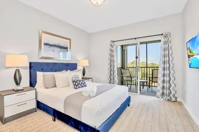 a bedroom with a king sized bed and a balcony at Relaxing 3BR Near Disney - Pool in Orlando