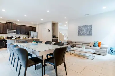 a kitchen and a living room with a table and chairs at Encore Resort 5 Bedroom Home with Pool 2201 in Orlando