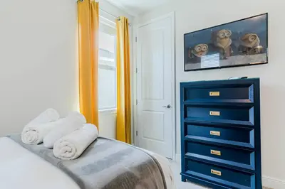 a bedroom with a blue dresser and a bed at Encore Resort 5 Bedroom Home with Pool 2201 in Orlando