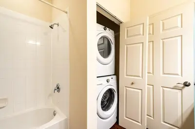 a bathroom with a washer and dryer next to a door at Super Comfy and Spacious 3 Bedroom 15-20 minutes from Disney, with major shopping 4 minutes away in Kissimmee