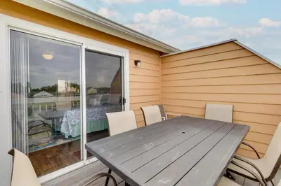 a wooden table and chairs on a patio with a window at Kissimmee Condo with Private Porch Less Than 7 Mi to Disney! in Kissimmee