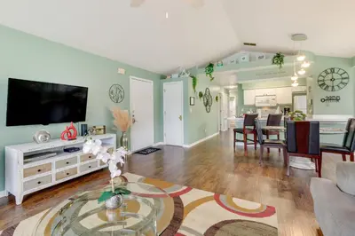 a living room with a television and a dining room at Kissimmee Condo with Private Porch Less Than 7 Mi to Disney! in Kissimmee