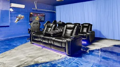 a black leather couch in a room with blue walls at Magical 7BR Resort Pool Home Near Disney & Orlando Attractions in Kissimmee