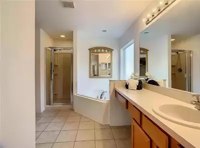 a bathroom with a tub and a sink and a bath tub at Family Oasis 5BR Villa with South Facing Pool and Games Room Near Disney in Kissimmee