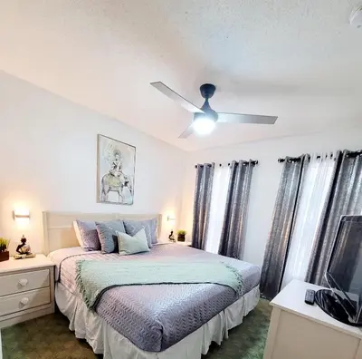 a bedroom with a bed and a ceiling fan at JC DISNEY House in Kissimmee