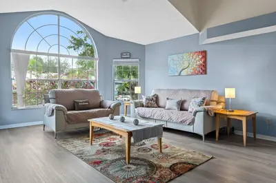 a living room with two couches and a table at Poinciana Paradise in Kissimmee