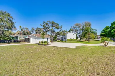 a large yard with a house and a driveway at Lakefront Retreat with Kayaks and Fire Pit in Clermont in Clermont