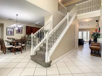 a staircase in a home with a dining room at Fantastic 7 Bed 6 Bath in Prestigious Gated Comm, villa in Orlando