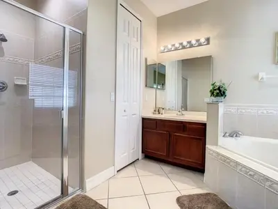a bathroom with a shower and a tub and a sink at Fantastic 7 Bed 6 Bath in Prestigious Gated Comm, villa in Orlando