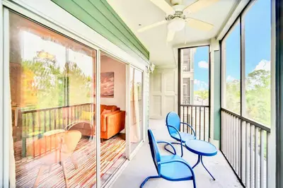 a balcony with blue chairs and a bed at 3BR Condo with Pool - Near Disney in Orlando