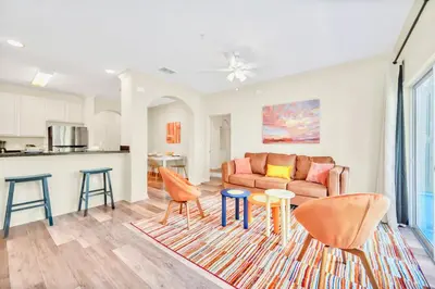 a living room with a couch and chairs and a kitchen at 3BR Condo with Pool - Near Disney in Orlando