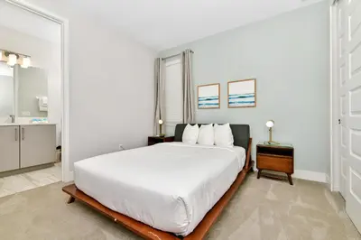a white bedroom with a large bed and a table at Modern Home Near Disney With Private Pool And Waterpark & Resort Access At Encore Resorts Reunion - 393Sf in Kissimmee