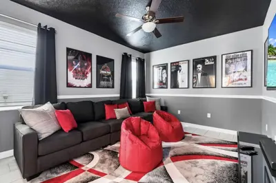 a living room with a couch and a ceiling fan at Delight Indoor Adventure Steps From Disney in Kissimmee